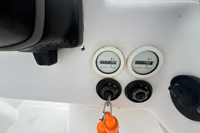 Slide: The Image of 1999 Donzi boat dashboard with engine hour meters and ignition switches. - 31