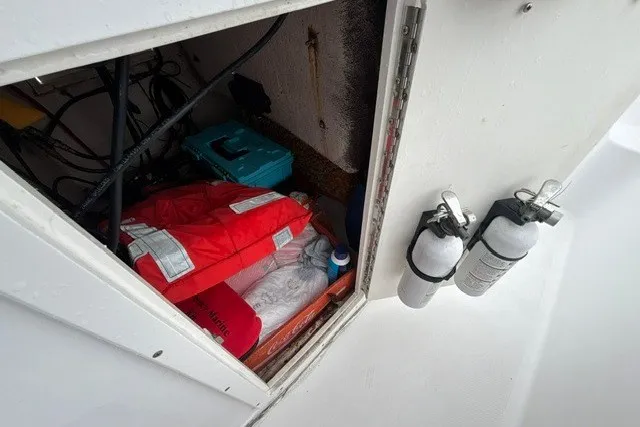 Slide: The Image of Storage compartment on a 1999 Donzi boat with life jackets and fire extinguishers. - 26