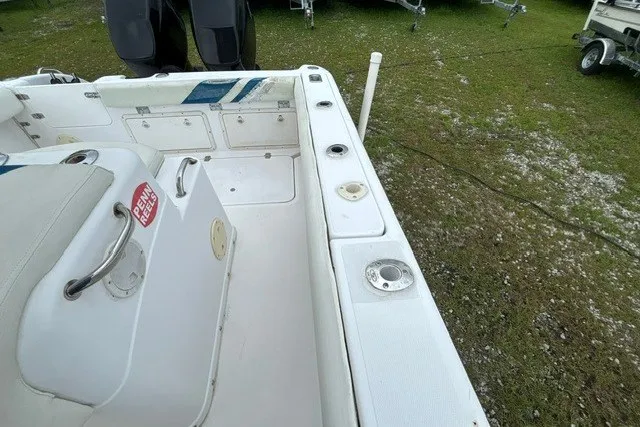 Slide: The Image of 1999 Donzi boat interior with white seating and storage compartments, parked on grassy area. - 38