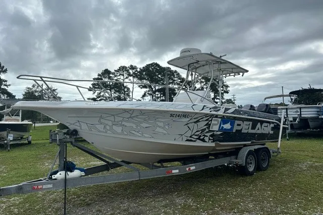 Slide: The Image of 1999 Donzi boat on trailer with Pelagic branding, parked outdoors under cloudy skies. - 47