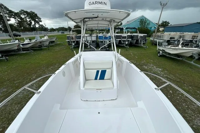 Slide: The Image of 1999 Donzi boat with Garmin equipment, white interior, and blue-striped seating, displayed outdoors. - 23