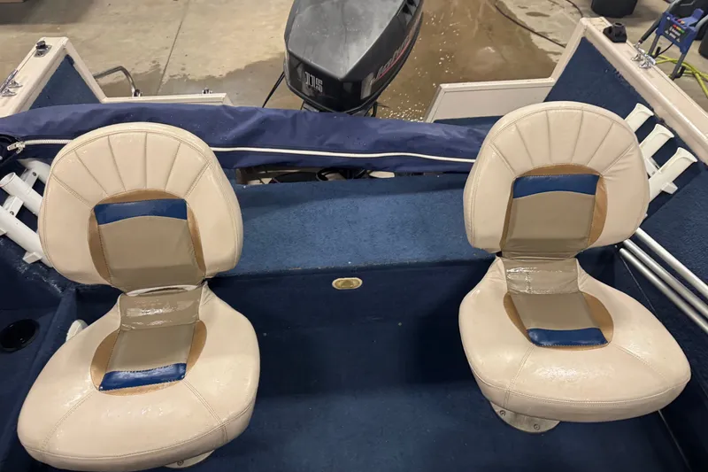 Slide: The Image of 2001 Crestliner 1700 boat interior with two beige seats and a motor at the back. - 9