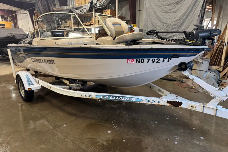 Slide: The Image of 2001 Crestliner 1700 boat on EZ Loader trailer in a garage setting. - 2