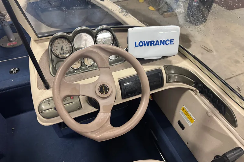 Slide: The Image of 2001 Crestliner 1700 boat dashboard with steering wheel and Lowrance fish finder. - 6