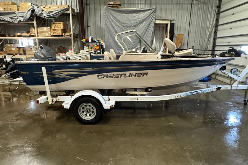 The Image of 2001 Crestliner 1700 boat on trailer in a warehouse setting. - 0