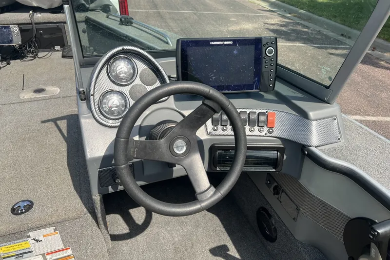 Slide: The Image of 2012 Alumacraft Trophy 175 boat dashboard with steering wheel and Humminbird fish finder. - 2