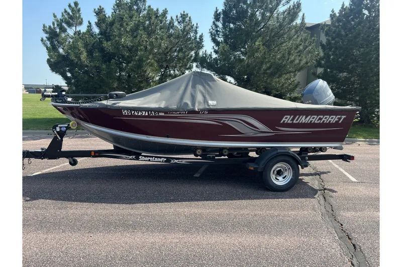 Slide: The Image of 2012 Alumacraft Trophy 175 boat on trailer, covered, parked outdoors. - 10