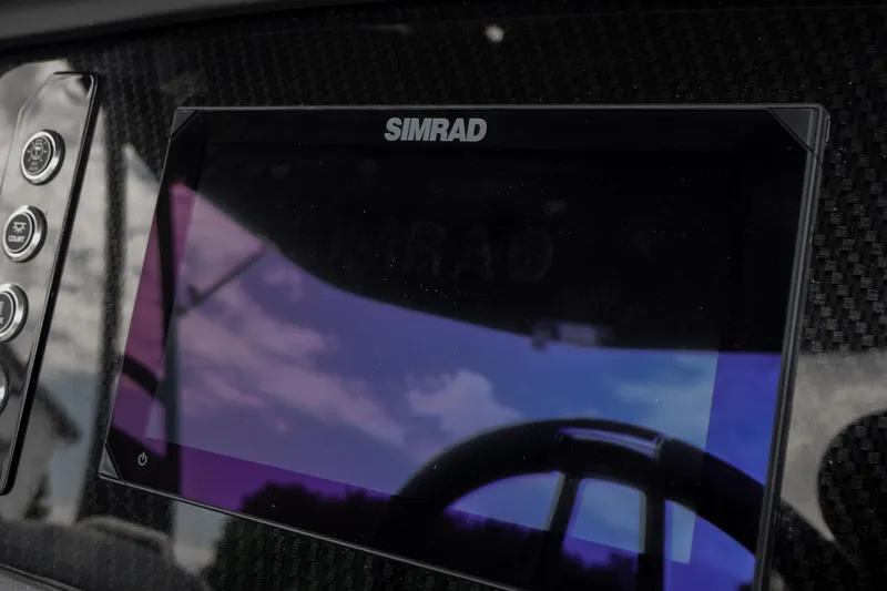 Slide: The Image of Simrad display on 2026 Chaparral SSX 4 boat dashboard, reflecting sky and surroundings. - 27