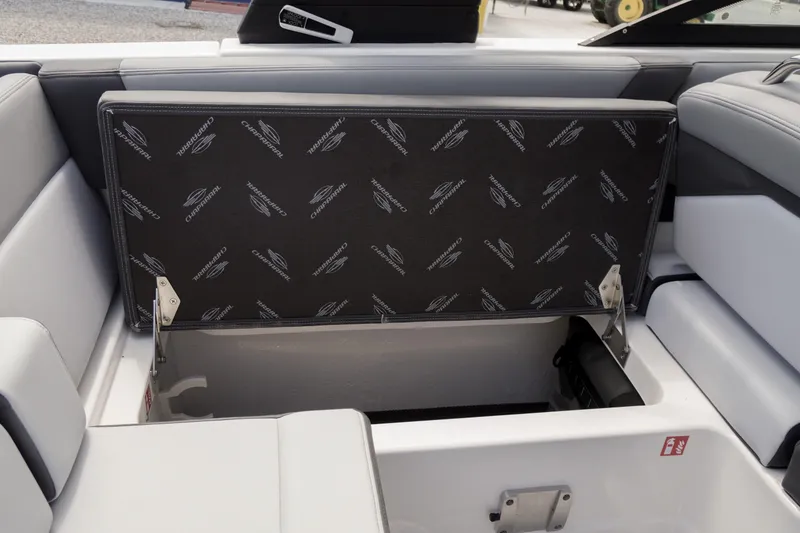 Slide: The Image of 2026 Chaparral SSX 4 boat storage compartment with branded upholstery and open lid. - 64