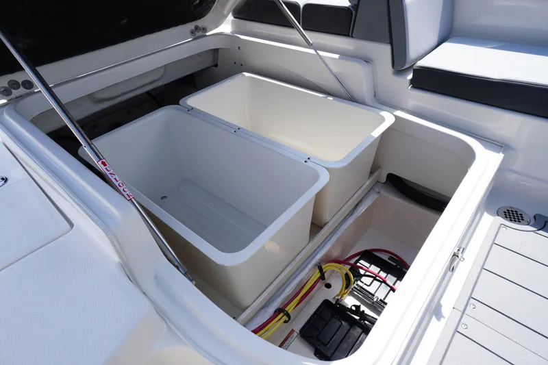 Slide: The Image of 2026 Chaparral SSX 4 boat storage compartments with open lids and visible wiring. - 55