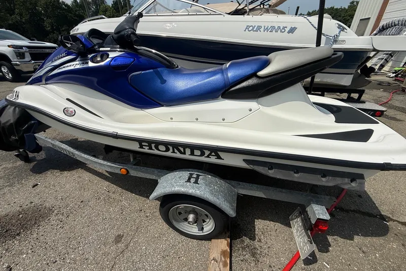 Slide: The Image of 2005 Honda Aquatrax F-12 jet ski on trailer, blue and white design. - 3