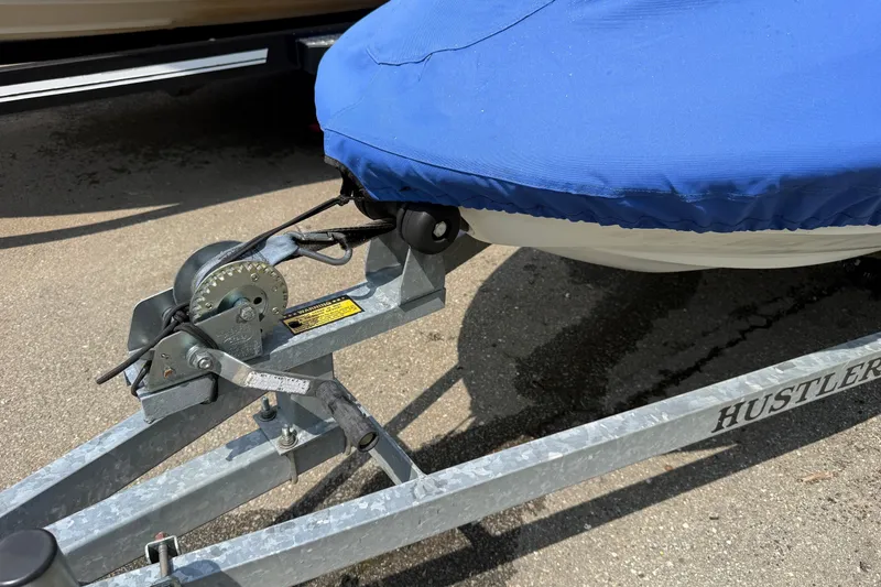 Slide: The Image of Trailer with blue-covered 2005 Honda Aquatrax F-12, featuring a Hustler winch system. - 12