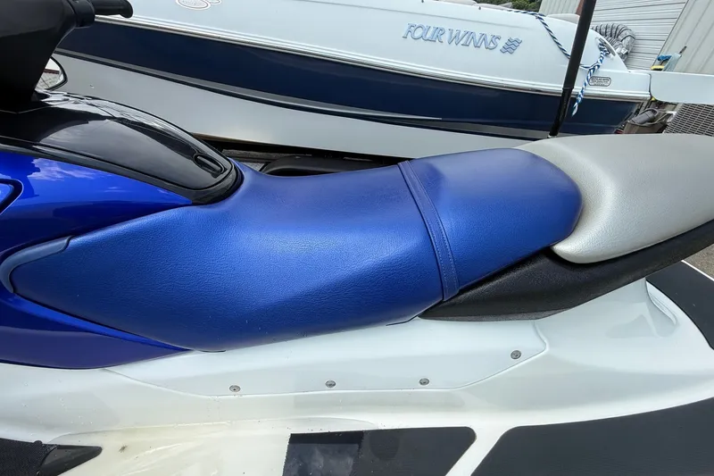 Slide: The Image of 2005 Honda Aquatrax F-12 jet ski with blue and gray seat, parked near a boat. - 6