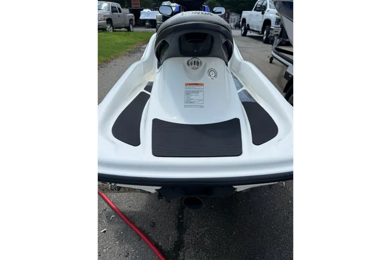 Slide: The Image of 2005 Honda Aquatrax F-12 jet ski, white with black accents, parked on pavement. - 4