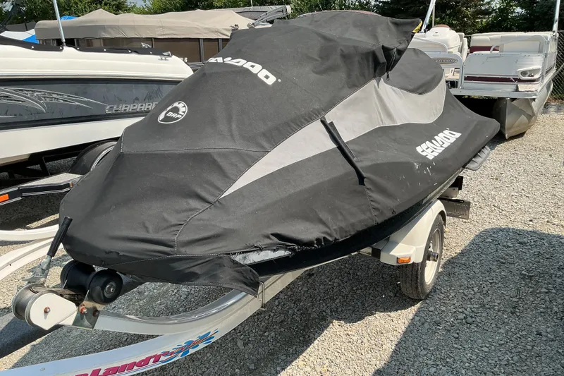 Slide: The Image of 2013 Sea-Doo GTI SE 130 jet ski covered, on trailer, parked outdoors. - 12