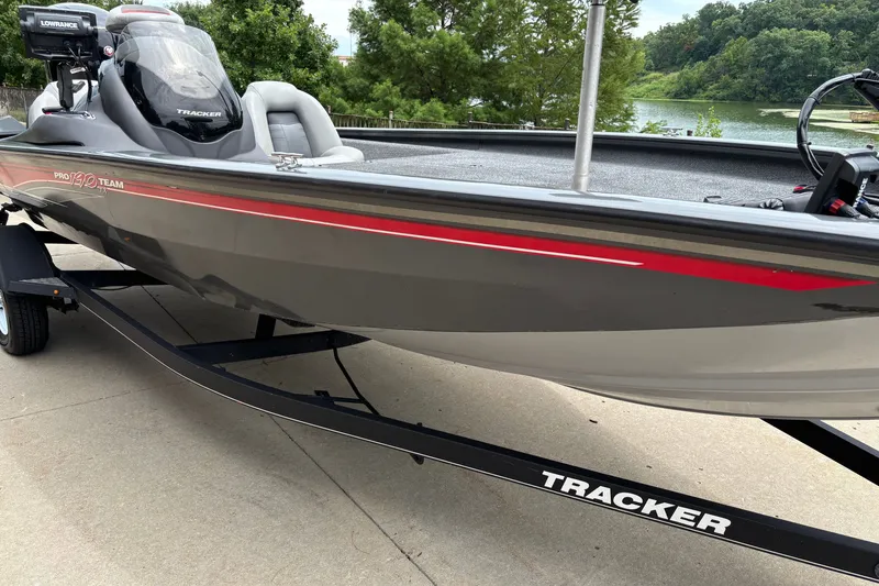 Slide: The Image of 2018 Tracker Pro Team 190 TX boat on trailer near a lake. - 9