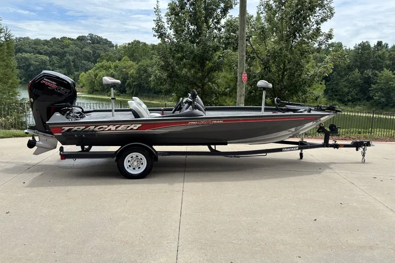The Image of 2018 Tracker Pro Team 190 TX boat on trailer, parked outdoors near trees. - 1