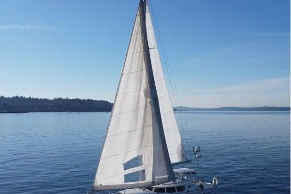 Slide: The Image of Sailboat Jeanneau Sun Odyssey 40 DS, 1999 model, cruising on calm waters under clear blue skies. - 2