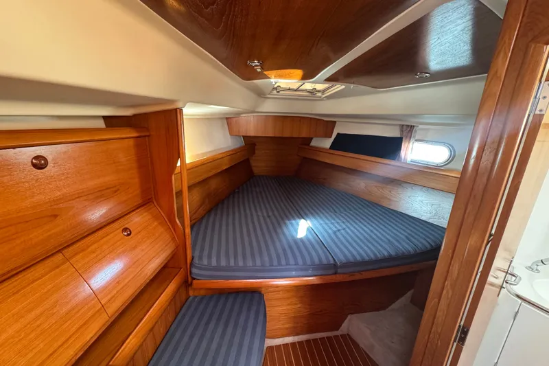 Slide: The Image of Cozy cabin interior of 1999 Jeanneau Sun Odyssey 40 DS with wood finish and striped bedding. - 9