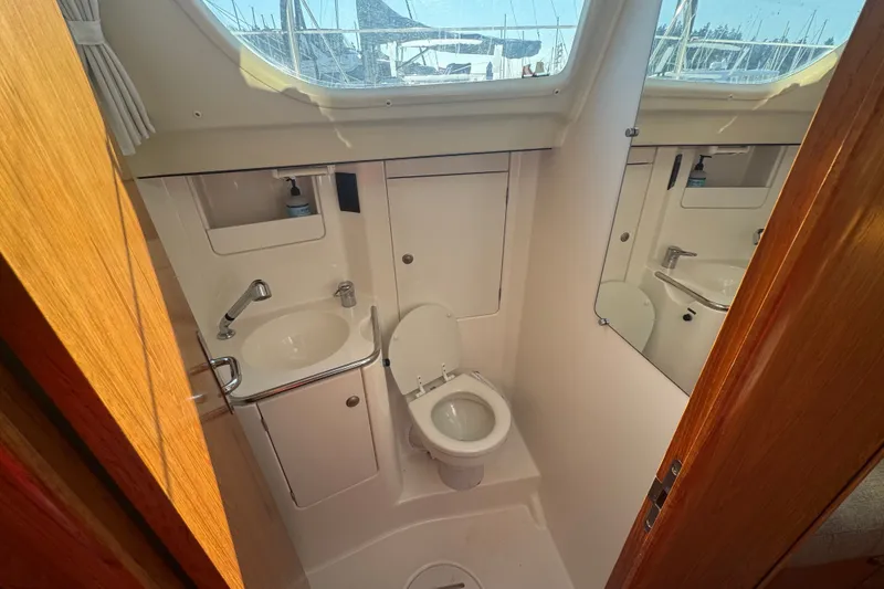 Slide: The Image of Bathroom interior of 1999 Jeanneau Sun Odyssey 40 DS yacht, featuring sink and toilet. - 17