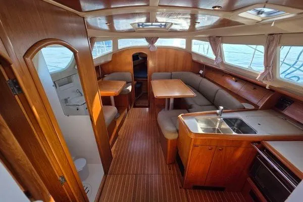 Slide: The Image of Interior of 1999 Jeanneau Sun Odyssey 40 DS sailboat with wood finish and seating area. - 7