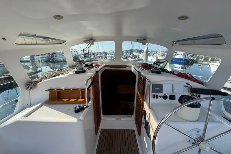Slide: The Image of Cockpit of 1999 Jeanneau Sun Odyssey 40 DS sailboat, featuring steering wheel and marina view. - 5