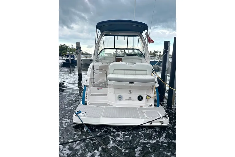 Slide: The Image of 2021 Regal 28 Express boat docked, rear view with seating and canopy. - 42