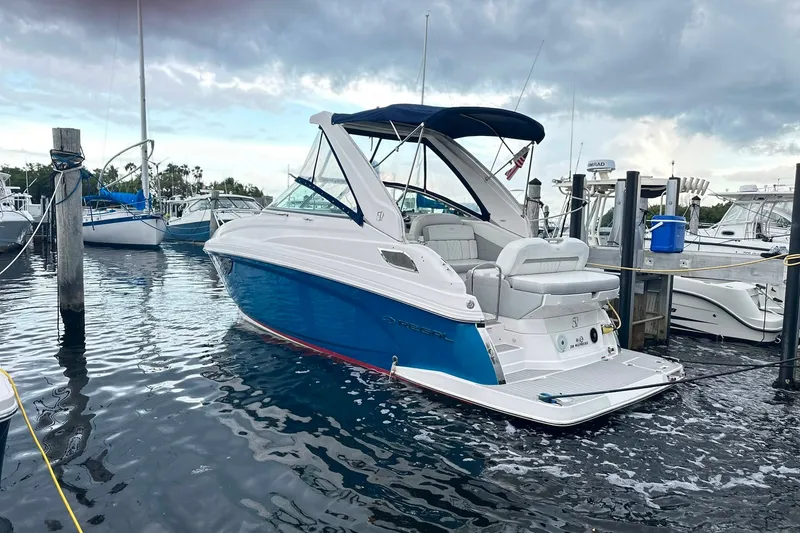 Slide: The Image of 2021 Regal 28 Express boat docked in marina, featuring sleek blue and white design. - 22