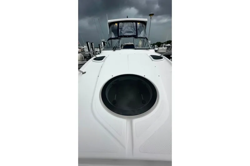Slide: The Image of 2021 Regal 28 Express boat docked under stormy skies. - 11