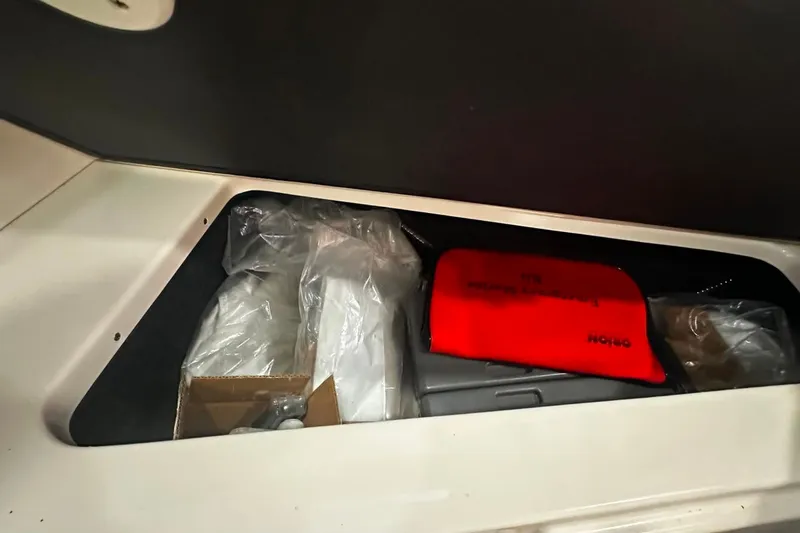 Slide: The Image of Storage compartment in a 2021 Regal 28 Express boat with safety equipment. - 33