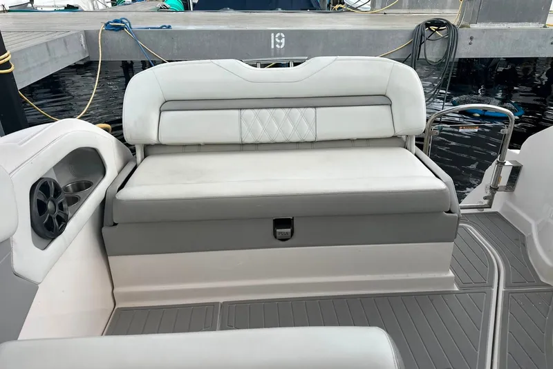 Slide: The Image of 2021 Regal 28 Express boat interior with white cushioned seating and speaker. - 14