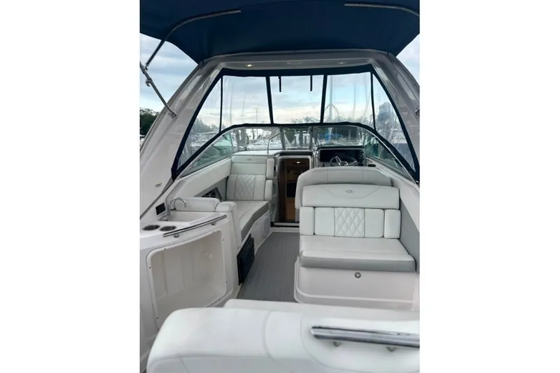 Slide: The Image of 2021 Regal 28 Express boat interior with white seating and blue canopy. - 2