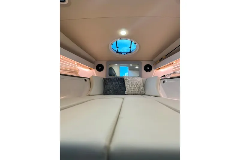 Slide: The Image of Interior cabin of 2021 Regal 28 Express boat with cushions and porthole. - 18