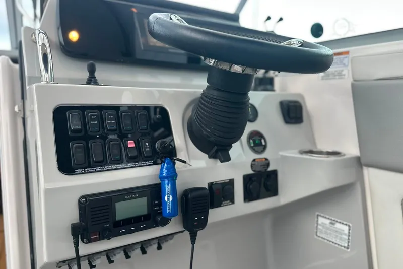 Slide: The Image of Control panel of 2021 Regal 28 Express boat with steering wheel and switches. - 20