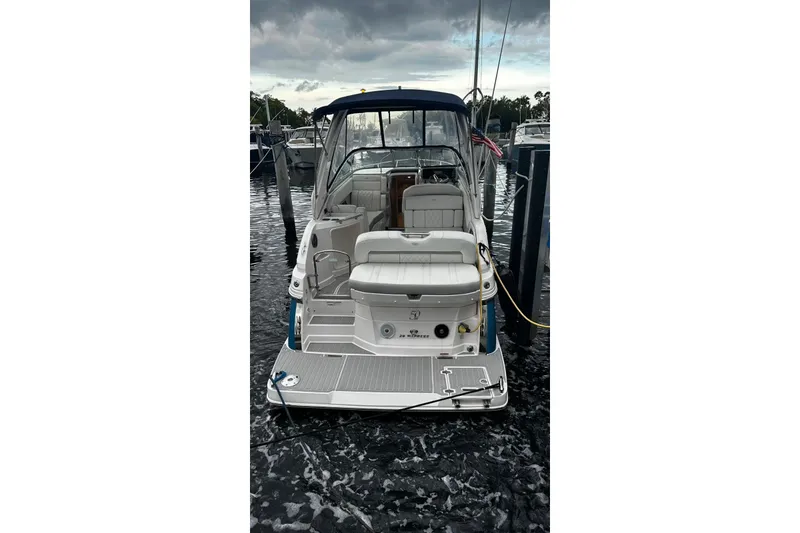 Slide: The Image of 2021 Regal 28 Express boat docked at marina under cloudy sky. - 25