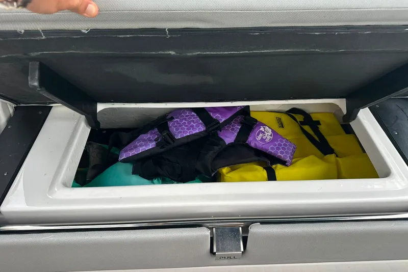 Slide: The Image of Storage compartment on a 2021 Regal 28 Express boat with life jackets inside. - 4
