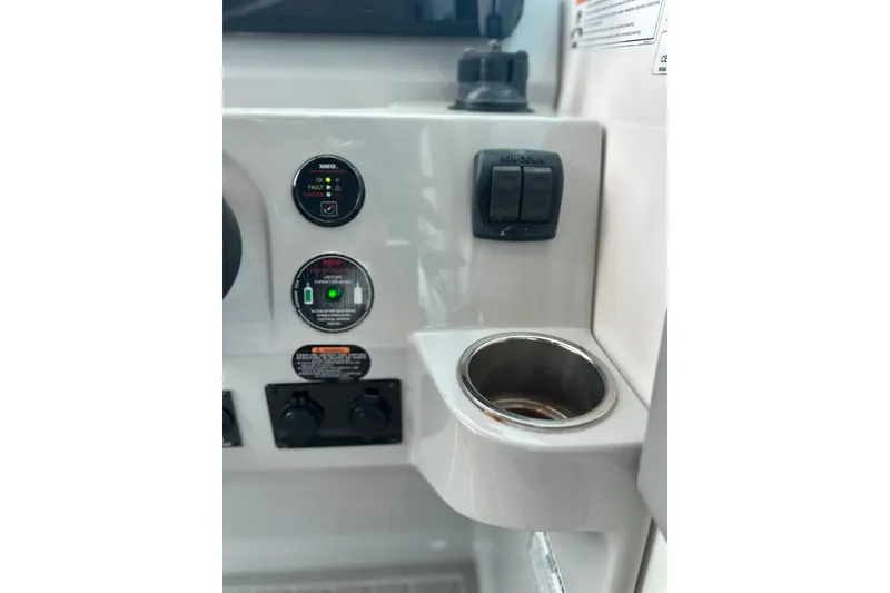 Slide: The Image of Control panel of 2021 Regal 28 Express boat with cup holder and switches. - 16
