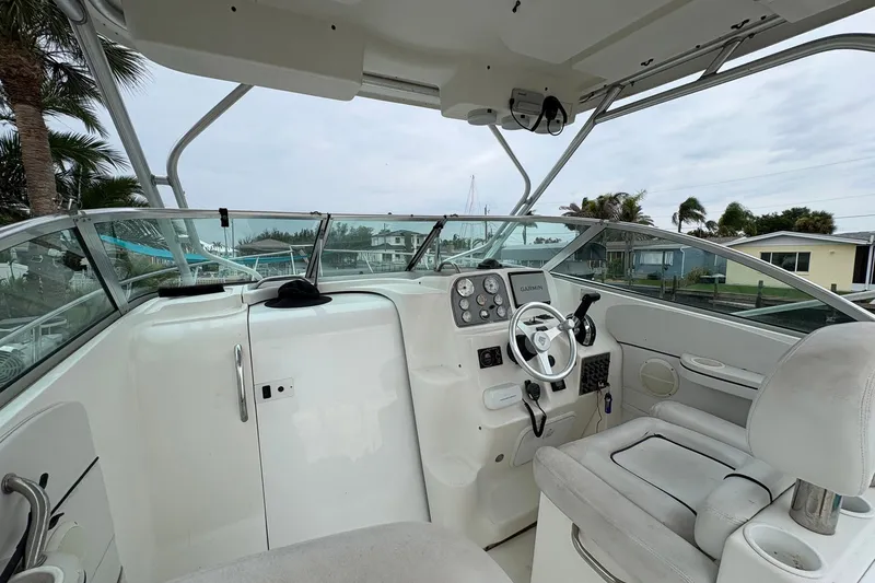 Slide: The Image of 2003 Wellcraft 270 Coastal I/O boat interior with steering wheel and dashboard controls. - 3