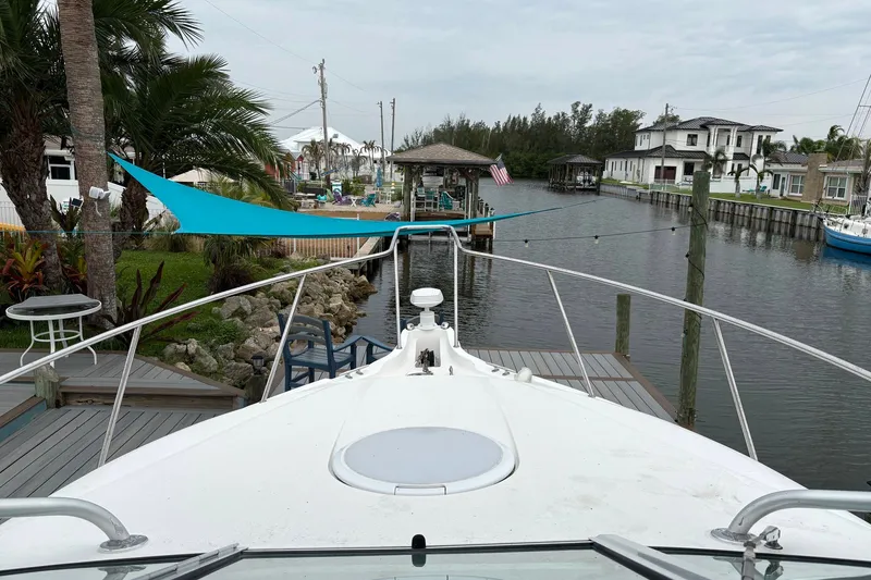 Slide: The Image of 2003 Wellcraft 270 Coastal I/O boat docked in a scenic canal with lush surroundings. - 8