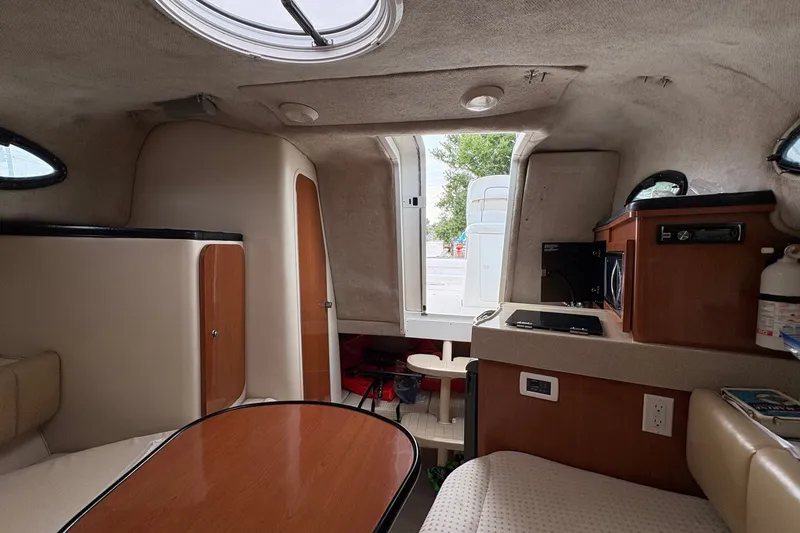 Slide: The Image of Interior of 2003 Wellcraft 270 Coastal I/O boat, featuring kitchenette and seating area. - 12