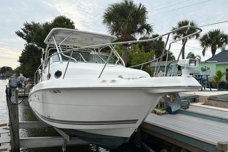 The Image of 2003 Wellcraft 270 Coastal I/O boat docked near palm trees. - 1