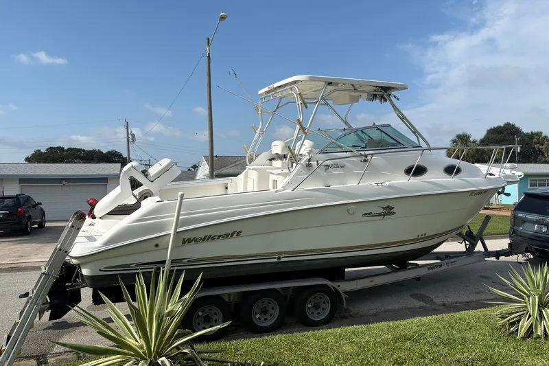Slide: The Image of 2003 Wellcraft 270 Coastal I/O boat on trailer, parked in residential area. - 17