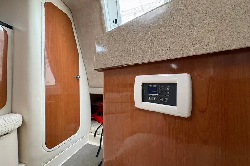 Slide: The Image of Interior of 2003 Wellcraft 270 Coastal I/O with control panel and wooden cabinetry. - 15