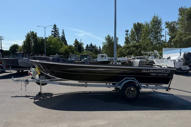 Slide: The Image of 2026 Alumaweld Free Drifter 20 boat on trailer in outdoor lot, surrounded by trees. - 4
