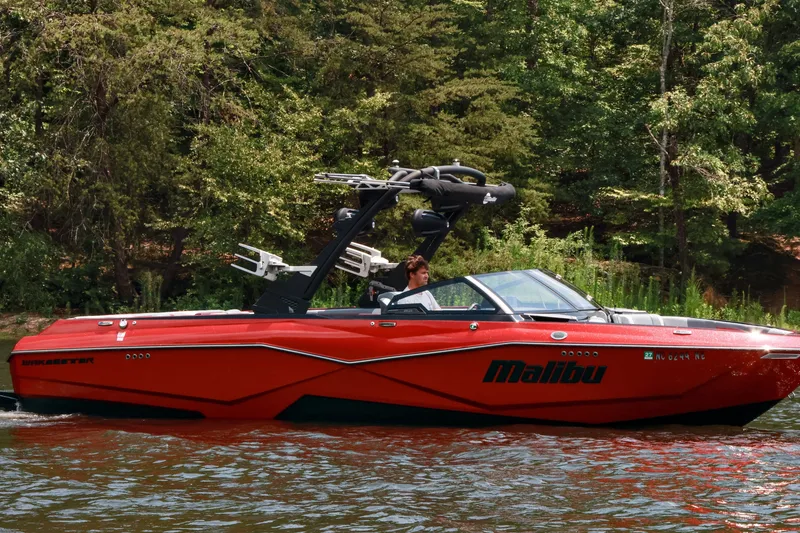 Slide: The Image of 2023 Malibu Wakesetter 25 LSV boat cruising on a scenic lake. - 7
