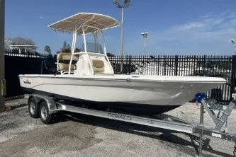 Slide: The Image of 2023 NauticStar 227 XTS boat on trailer, parked outdoors. - 2