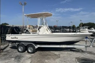 The Image of 2023 NauticStar 227 XTS boat on trailer, parked outdoors under clear sky. - 1