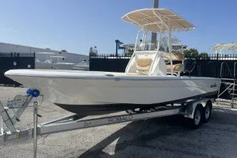 Slide: The Image of 2023 NauticStar 227 XTS boat on trailer, parked outdoors under clear blue sky. - 4