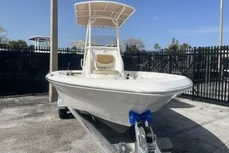 Slide: The Image of 2023 NauticStar 227 XTS boat on trailer, featuring a sleek design and T-top canopy. - 3