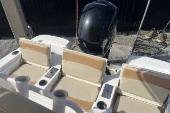 Slide: The Image of 2023 NauticStar 227 XTS boat seats and motor, featuring beige and white upholstery. - 13